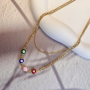Detailed view of 18K gold double-layer necklace with four colorful evil eye enamel charms