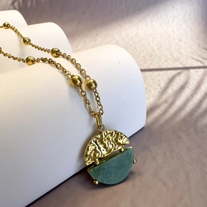 Detalle del collar de cadena de oro 18k con colgante de piedra de jade africana