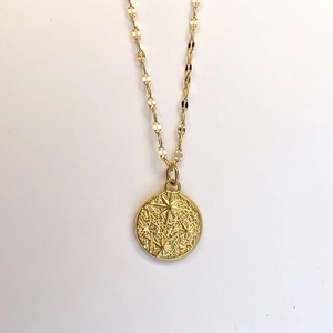 Macro view of French vintage hammered coin pendant with embossed eight-pointed star motif