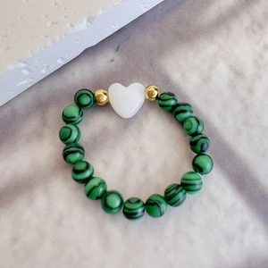 Bague élégante en perles de malachite avec un charm cœur blanc sur cordon élastique