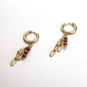 Dettaglio di orecchini a catena placcati oro 18K con ciondoli in pietra rosso-marrone