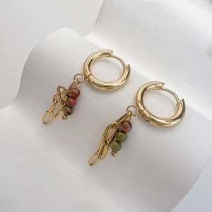 Dettaglio di orecchini in oro 18K con perline di pietra naturale e catena sottile