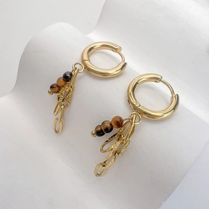 Dettaglio di orecchini a cerchio placcati oro 18K con pietre occhio di tigre e catene