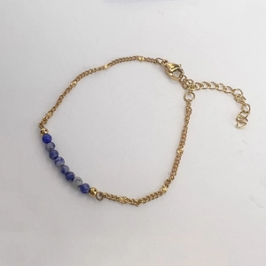 Detail einer vergoldeten Kette mit blauen Natursteinperlen und Sternanhängern
