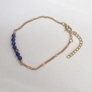 Detail eines Goldkettenarmbands mit blauen Lapislazuli-Perlen und verstellbarem Verschluss