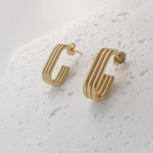 Close-up of 18K gold plated stainless steel C-hoop earrings with triple layered ridges