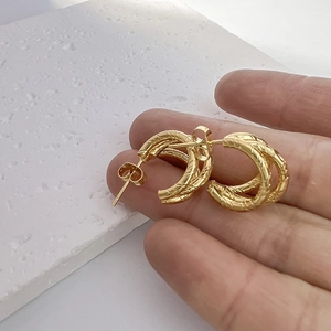Fashionable 18K gold plated stainless steel twisted rope earrings shown in hand