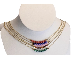 Set of five gold tone necklaces with colorful natural stone beads on a jewelry display