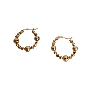 Polished gold stainless steel hoop earrings with gradient beaded design on white background