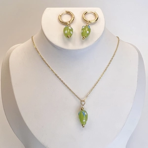 Détail du collier et des créoles en acier inoxydable avec pendentifs en verre vert