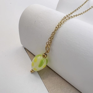 Vue détaillée du collier doré avec pendentif fraise en verre rayé coloré artisanal