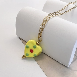Minimalist stainless steel necklace with a yellow heart pendant and green dotted details