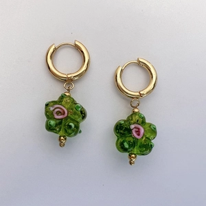 Détail de créoles dorées vintage avec pendentifs fleurs en verre fait main