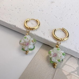 Vue détaillée de boucles d'oreilles fleurs en verre artisanal avec feuilles d'or pur