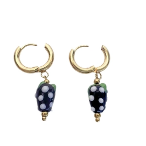 Pair of gold-toned hoop earrings featuring dark blue strawberry pendants with white polka dots
