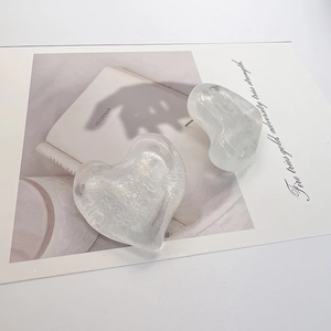 Close-up of large heart-shaped resin stud earrings with water-wave texture