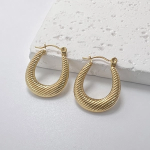 Vue détaillée des boucles d'oreilles dorées en U avec design à texture spirale