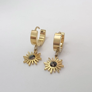 Détail des boucles d'oreilles créoles en acier doré 18K avec pendentifs soleil noir