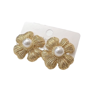 Golden matte flower stud earrings with pearl centers on a white jewelry display card