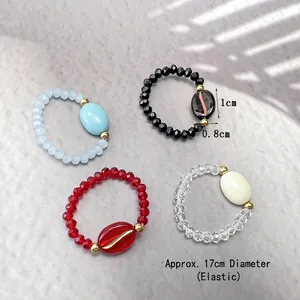 Elegant beaded coffee bean rings in light blue, black, red, and clear glass with gold accents