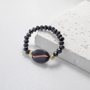 Macro view of black faceted beads and centerpiece bead with rose gold leaf pattern