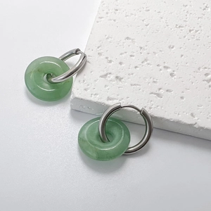 Makro-Detail von Silber-Creolen mit durchscheinenden grünen Jade-Anhängern in Donut-Form