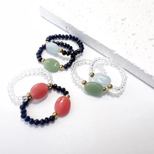 Set di anelli di perline luminose con pietre di vetro nere e trasparenti e dettagli oro