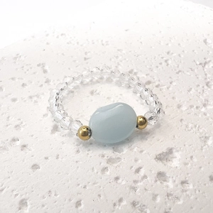 Dettaglio ravvicinato dell'anello con perle di vetro azzurro e cristalli trasparenti