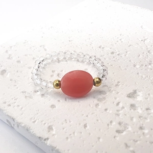 Primo piano di un anello di perline con pietra ovale rossa e perline di cristallo trasparente