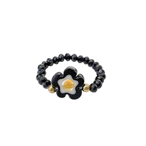 Handgefertigter elastischer Perlenring mit schwarzen Kristallen und Blumen-Charm-Detail