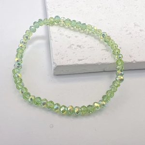 Detail of light green faceted crystal bracelet with rainbow AB coating on white background