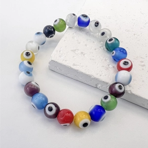 Detailed close-up of multi-colored Evil Eye glass beads on a stretch elastic bracelet