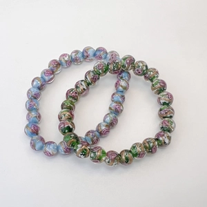 Détail de bracelets en perles de verre faits main avec roses et accents de sable doré