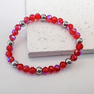 Macro detail of red faceted glass beads with AB coating and silver metal bead accents