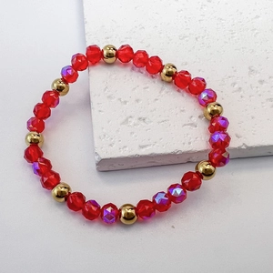 Detailed view of red faceted beads and gold spacers on a stretch beaded bracelet