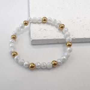 Detail of 6mm milky faceted beads and golden polished beads on an elastic bracelet