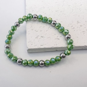Macro detail of 6mm light green faceted beads and silver steel beads on elastic bracelet