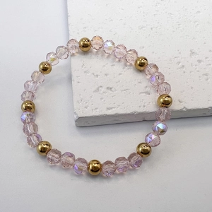 Detailed view of faceted pink glass beads and golden stainless steel ball bracelet