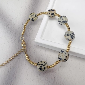 Détail de perles en or 18K et pierres d'agate sur un bracelet perlé avec fermoir