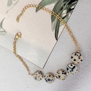 Detailed macro view of gold-plated stainless steel chain with natural tiger eye stones