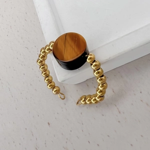 Detail of 18K gold beaded open ring featuring a round natural tiger eye gemstone