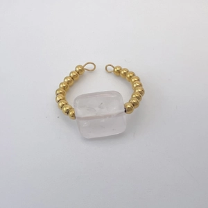 Macro view of 18K gold beaded band ring featuring a square transparent gemstone