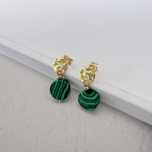 Detail of green malachite stone earrings with hammered gold metal discs on white background