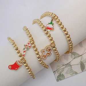 Set of four Christmas charm bracelets with 4mm golden beads featuring enamel festive pendants