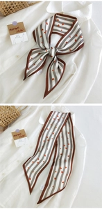 Détail d'un foulard en soie rayé gris avec des cœurs rouges sur une chemise