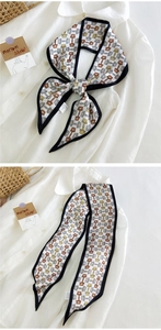 Détail d'un foulard étroit en soie à motif mors de cheval vintage sur fond blanc