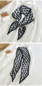 Détail d'un foulard en soie géométrique noir et blanc noué sur un col de chemise blanc