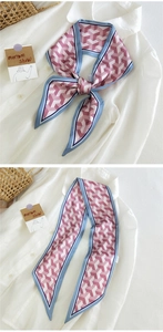 Détail d'un foulard en soie rose à motif géométrique stylisé sur un col de chemise