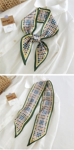 Détail d'un foulard étroit en soie à motif pied-de-poule vert et marron sur chemise
