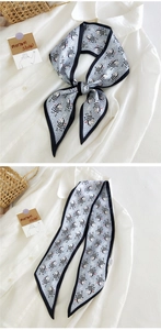 Détail d'un foulard twilly bleu à motif zèbre sur une chemise et présenté à plat